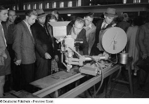 Besucher betrachten ein Exponat der Leipziger Herbstmesse 1954