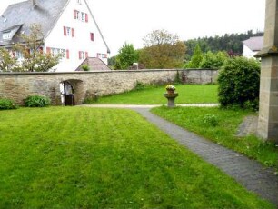 Kirchhof im Osten mit Kirchhofmauer (Wehrgang mit Steinbrüstung im 18 Jh abgetragen) sowie ehemaliger Toranlage (nur Außenbogen erhalten) nach Südosten