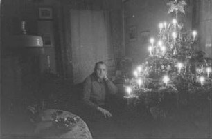 Private Aufnahmen. Mann neben einem Weihnachtsbaum