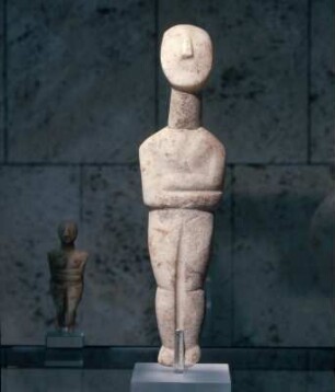 Stehendes weibliches Idol : München, Antikensammlung. Weibliches Idol, Frühe Spedos-Art, Frühkykladisch II. Trapezförmige Armhaltung, Beindurchbrechung. Im Hintergrund links: Weibliches Idol mit verschränkten Armen (Spedos-Art), Inv.Nr. 263