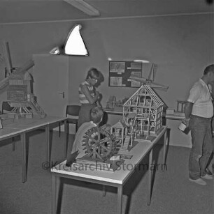 Ausstellung: Rathaus und Bürgerhaus Glinde [später Marcellin-Verbe-Haus]: Heimatverein Glinde: Mühlenmodelle auf Tischen: dazwischen Kinder und Erwachsene als Besucher