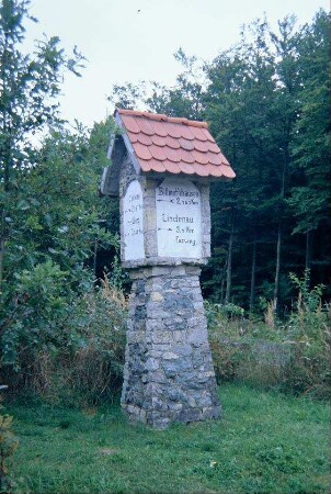 steinerner Wegweiser außerhalb des Ortes Richtung Heldburg, 4 Seitenflächen mit rundbogigen Spiegelfeldern