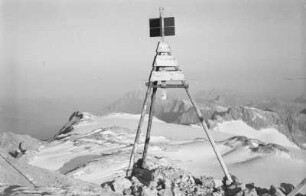 Vermessungszeichen : Hölzernes, dreibeiniges Vermessungszeichen auf einem Berg.