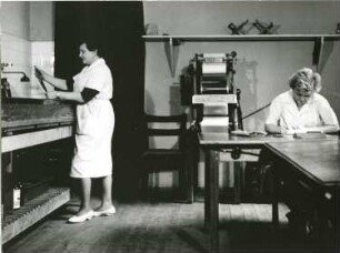 Dresden, Ständehaus. Deutsche Fotothek. Labor. Laborantin und Retuscheurin bei der Arbeit. Im Hintergrund Trockenmaschine