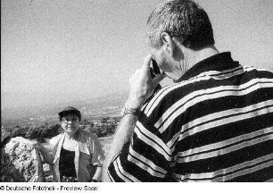 Mann fotografiert Frau in hügliger Landschaft