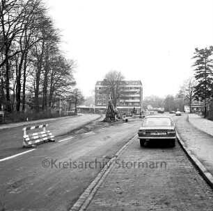 Möllner Landstraße: vorn neue Straßenführung: links alte Straßenführung: dazwischen Absperrung und Bauarbeiten: vorn rechts parkender Pkw: hinten Mitte Wohn- und Geschäftsblock: links Baumreihe