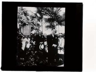 [Fotografia de Vítor Konder em frente a um monumento em sua homenagem]
