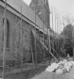 Martin-Luther-Kirche: Außenansicht von Nordosten: Renovierung der Nordwand: davor Holzgerüst: rechts herausgebrochene Feldsteine