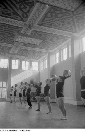 Sportlerinnen während einer Übung mit einem Medizinball in einer Sporthalle der Deutschen Hochschule für Körperkultur in Leipzig