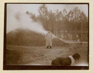 Foto eines Soldaten vor einem Meiler in der Köhlerei bei der Köhlerwiese