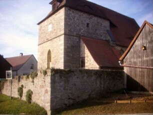 Ansicht von Nordosten mit Kirche (romanische Gründung 12 Jh) über (einst fester) Kirchhofmauer (Wehrgang mit Steinbrüstung und Schießscharten abgetragen)