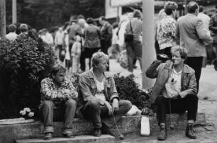 Kreiserntefest. Drei Männer bei einem Imbiß