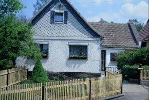 Einfamilienhaus mit Vorgarten und Holzzaun