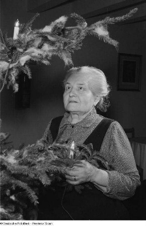 Porträt einer alten Frau an einem Weihnachtsbaum