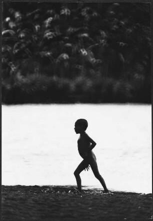 Silhouette eines Jungen vor einem Gewässer