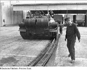 Goldberg (Kreis Lübz). Nationale Volksarmee - Landstreitkräfte. Panzerregiment 8 (PR-8). Freifläche vor Panzerhallen. Soldaten bei Instandsetzungs- bzw. Wartungsarbeiten an Gleisketten für Kampfpanzer T-54