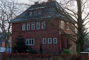 Tremsbütteler Weg 70: traufständiges Wohnhaus aus Backstein mit umlaufendem Gesims: Straßenfront, in Obergeschoss Fensterband: Giebelseite, vorgebauter Eingang, Treppe: Sprossenfenster: Vorgarten, vorne Gartenhecke, Baum