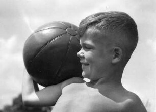 Sport und Spiel. Kleiner Junge mit ledernem Ball