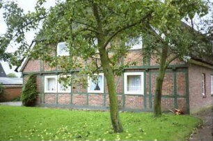 Dorfstraße 22: Bauernhaus mit Reetdach: Giebelseite mit Fachwerk und Vorkragung