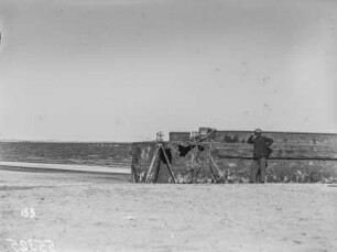 Kamera am Strand : Blick auf ein Kai mit Kamera und Mann davor