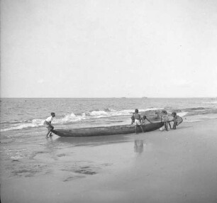 Fischerboot : Ein Fischer zieht sein Boot zusammen mit Kindern auf den Strand.
