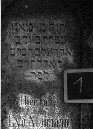 Grabstein 1 (Index: 100101069) Material: Kalkstein Zustand: leicht verwittert Maße HxBxT: 116x61x8 cm Beschreibung: Stele, giebelartiger Abschluß mit Eckakroteren, eingetieftes Schriftfeld mit Rundbogen: Grabstein 1A
