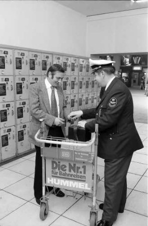 Freiburg: Hauptbahnhof; Herausholen des Kastens mit dem Zeitungstitel der heutigen Ausgabe