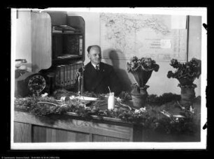 Mitarbeiter am Schreibtisch und zahlreicher Blumenschmuck