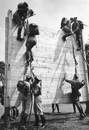Ein Sturm der SA wird militärisch ausgebildet. Hier überwinden die Männer in voller Ausrüstung und Waffe eine Eskaladierwand. Aufgenommen 1939
