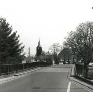 Schlepzig. Dorfstraße. Ansicht mit Straßenbrücke und Dorfkirche