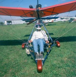 Ultraleichtflugzeug mit Pilot. Unter dem Steuerknüppel (rechter Arm) ist der Kraftstofftank sichtbar