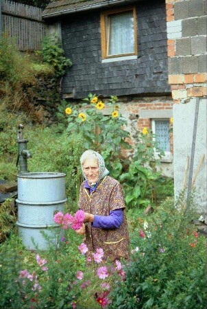 Frau im Garten, pflückt Blumen