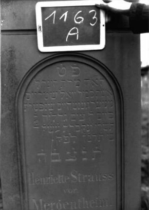 Grabstein 1163 (Index: 100104290) Material: Sandstein Zustand: gut erhalten, nur in Bodennähe verwittert Maße HxBxT: 176x56x22 cm Beschreibung: aufgesockelte Stele, Giebelaufsatz, Eckakroterien mit eingeritzten Voluten, Ranken und Blüte, eingetieftes Schriftfeld mit mehrfach profiliertem Rundbogenabschluss Symbolik: Voluten, Ranken, Blüte: Grabstein 1163A
