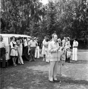 Dorffest der Dorfgemeinschaft Klein Wesenberg: Begrüßung durch Herbert David, Vorsitzender der Dorfgemeinschaft: im Hintergrund Besucher und Kleinbus: hinten Bäume
