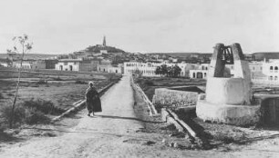 Ghardaia : Blick über die Stadt Ghardaia, rechts ein Brunnen, im Hintergrund ein Minarett