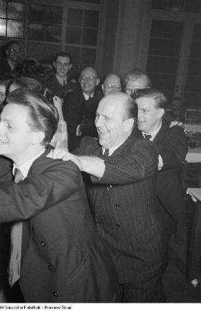 Gäste einer Betriebsweihnachtsfeier beim Tanzen einer Polonaise