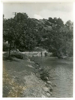 Halberstadt-Langenstein. Ortsteilansicht von Langenstein. Blick über einen Bach gegen die "Altenburg" (Ruine, nach Zerstörung abgetragen)