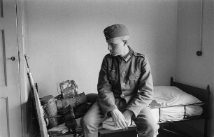 Zweiter Weltkrieg. Niederlande unter deutscher Besatzung. Unterkunft deutscher Wehrmachtsangehöriger (wohl bei Den Haag). Franz Grasser, auf seinem Feldbett mit Marschgepäck sitzend