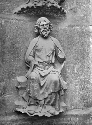 Nördliches Westportal — Südlicher Türpfosten — Sitzende Figur, a 7