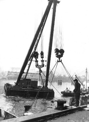 Hamburg. Hafen. Ein Schwimmkran hebt Wrackteile von, während der Bombardierung der Hansestadt, gesunkener Schiffe aus dem Hafenbecken.