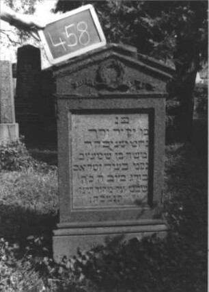 Grabstein 458 (Index: 100111700) Material: Sandstein Zustand: beschädigt, sonst gut Maße HxBxT: 105x55x23 cm Beschreibung: Stele, profilierter Sockel, giebelartiger Abschluß mit Verdachung, rechteckiges Schriftfeld eingetieft Symbolik: Kranz mit Schleife: Grabstein 458