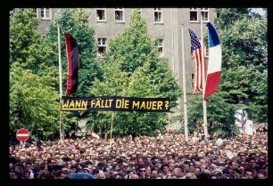 Rudolph Wilde-Platz/ Menschenmenge, Fahnen u.Transparent "Wann fällt die Mauer?"