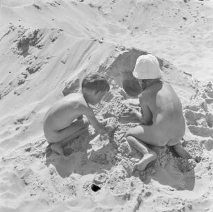 Zwei Kinder spielen am Strand