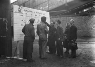 Industrie-Kraftwerk. Arbeiter vor der Schautafel "Bruttoproduktion des Kraftwerkes Lauta" während der Laufzeit des Fünfjahrplans 1951-1955 : Lauta (Niederlausitz). Industrie-Kraftwerk. Arbeiter vor der Schautafel "Bruttoproduktion des Kraftwerkes Lauta" während der Laufzeit des Fünfjahrplans 1951-1955