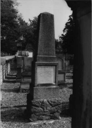 Grabstein 236 (Index: 99796987) Material: Granit, weiße Marmorplatte Zustand: gut Maße HxBxT: 265x73x60 cm Beschreibung: psotamentierter Obelisk, rechteckige Schriftplatte: Grabstein 236