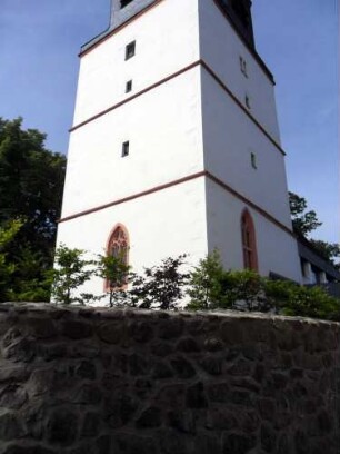 Evangelische Kirche - Kirchturm (Spätgotische Gründung um Jahr 1500 als Chorturm mit Turmchor) von Nordosten mit Maßwerkfenstern im Turmchor sowie Schlitzscharten über Kirchhofmauer