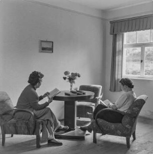 Rat des Kreises : Oberlausitz. Unbekannter Ort, Bibliothek. Sitzgruppe mit zwei lesenden Frauen