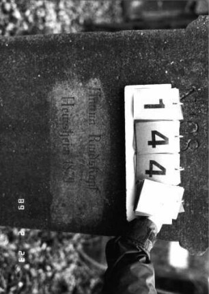 Grabstein 144 (Index: 99751960) Material: Sandstein Zustand: abgeblättert mit Textverlust Maße HxBxT: 160x55x15 cm Beschreibung: Stele, SOckel, Giebel, rechteckiges Schriftfeld eingetieft: Grabstein 144B