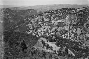 Landschaftsblick : Blick auf Berghang und Tal unterhalb des Dorfes Aït Aïssa Mimoune. Im Tal befinden sich Getreidefelder.