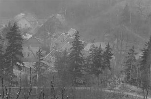 Blick in ein Tal mit Fachwerkhäusern, im Vordergrund die Gaststätte "Deutsches Haus"